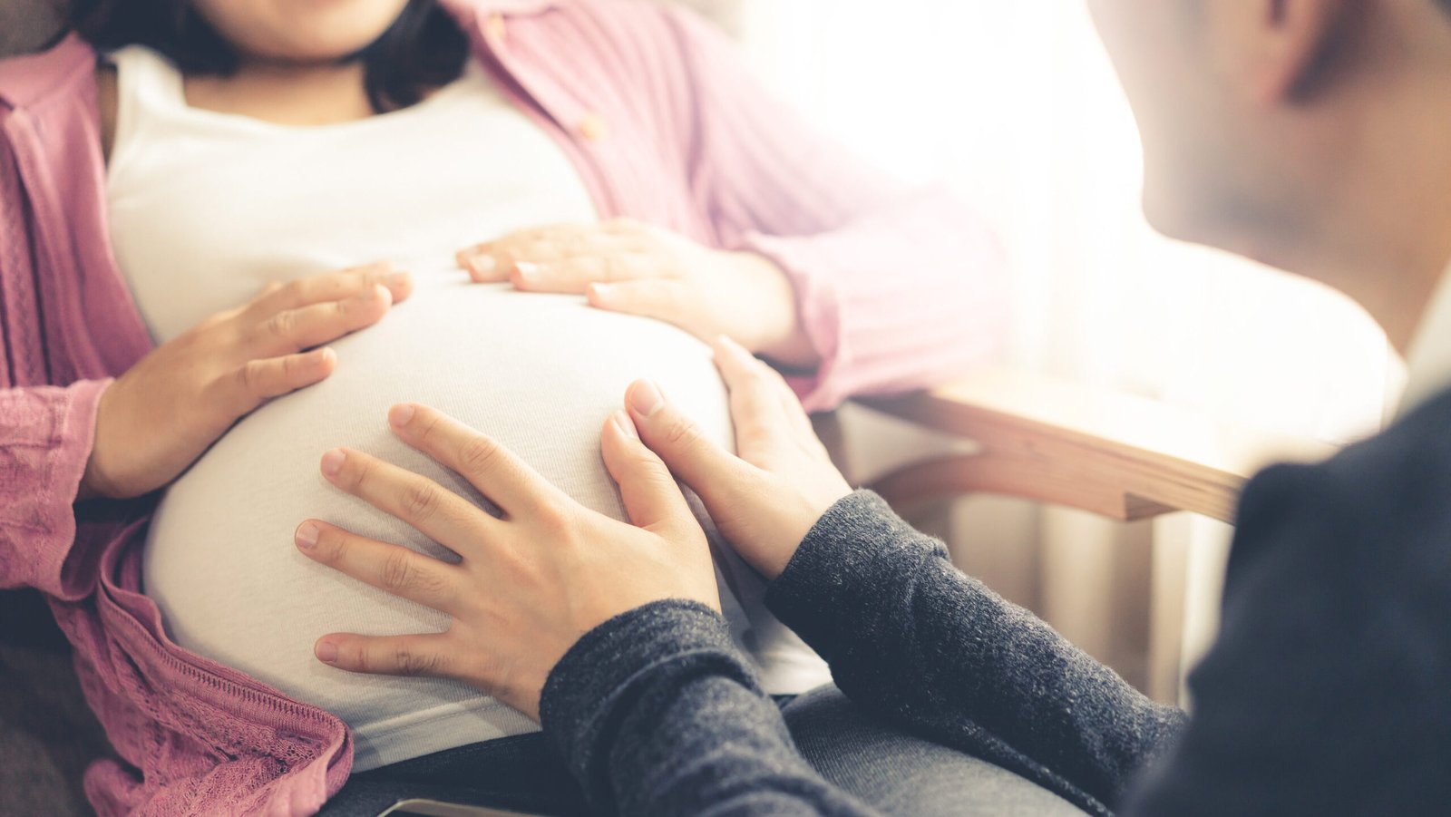 L’attribut alt de cette image est vide, son nom de fichier est happy-pregnant-couple-husband-wife-young-expecting-woman-holds-baby-pregnant-belly-edited-scaled.jpg.